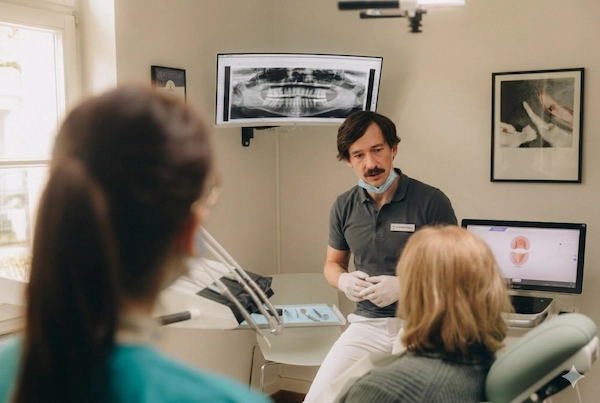 Dr Adalbert Skoberla berät Patientin in Zahnarztpraxis ZAE Bonn